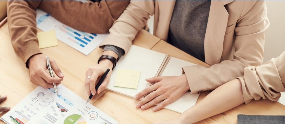 Individuals sitting at a table looking at charts.